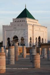 Image du Maroc Professionnelle de  Le tombeau du plus populaire des sultans du Maroc, Mohammed V, père de l’indépendance repose ici dans cette  demeure bâtie en marbre blanc et couronnée par un toit pyramidale orna de tuiles vertes, symbole de la royauté. Sa construction a nécessita une dizaine d’année, au premier plan  les colonnes de l’esplanade de la Mosquée Hassan à Rabat, Jeudi 1er Mars 2007. (Photo / Abdeljalil Bounhar)
